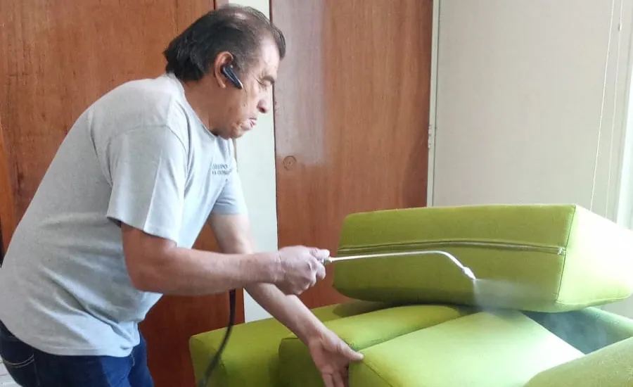 Técnico aplicando protector de teflón en un sillón